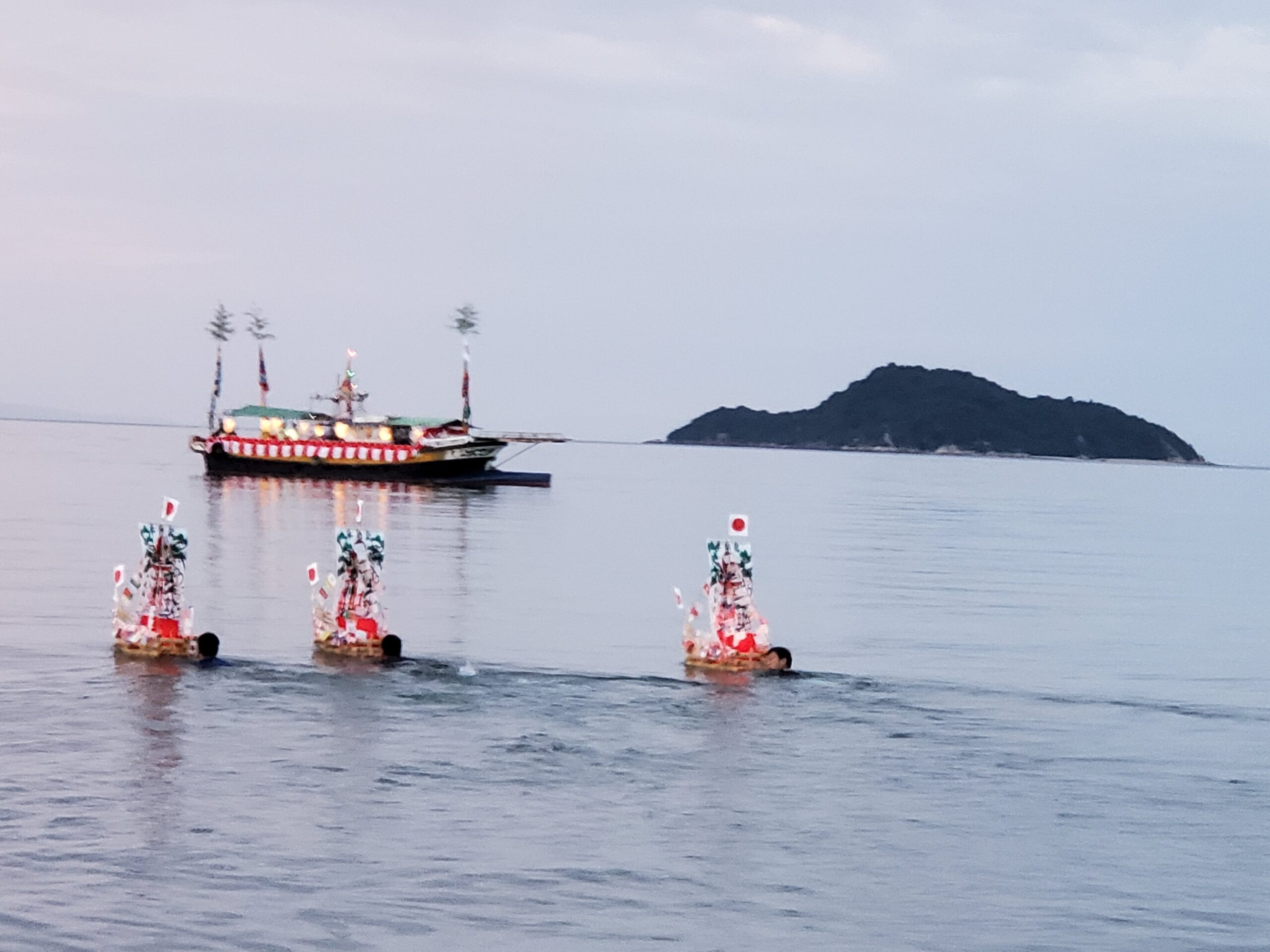 ④日没前のわら舟流し